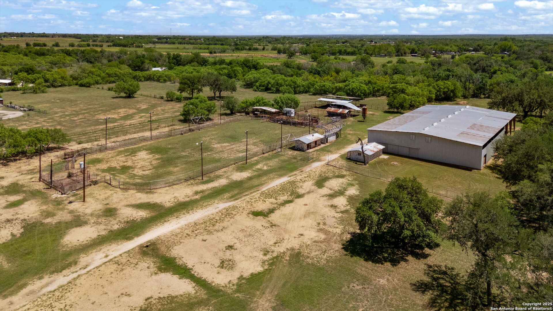 11224 Atkins Road Atascosa, TX 78002 - Photo 20 of 45 a view of a big yard with lawn chairs under an umbrella