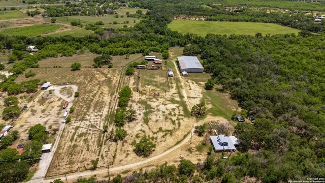 an aerial view of residential house with outdoor space and trees