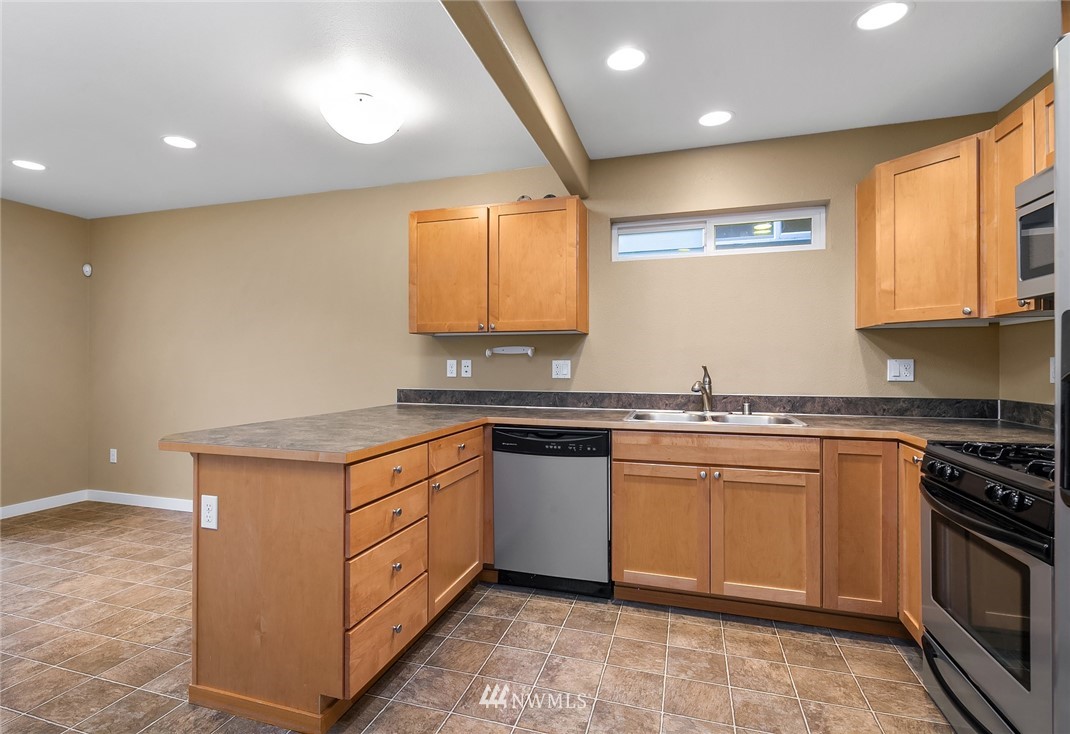 21006 42nd Avenue Southeast, Unit A Bothell, WA 98021 - Photo 8 of 19 a kitchen with stainless steel appliances granite countertop a stove a sink and a microwave
