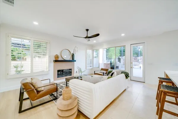a living room with furniture fireplace and a large window