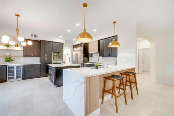 a kitchen with kitchen island a stove a table a sink and a refrigerator