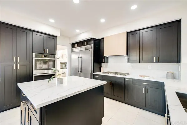 a kitchen with stainless steel appliances a sink and refrigerator