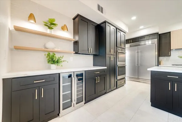 a kitchen with stainless steel appliances granite countertop a refrigerator and a sink