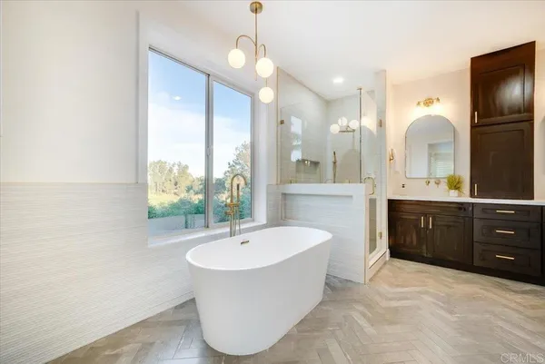 a spacious bathroom with a tub sink shower and mirror