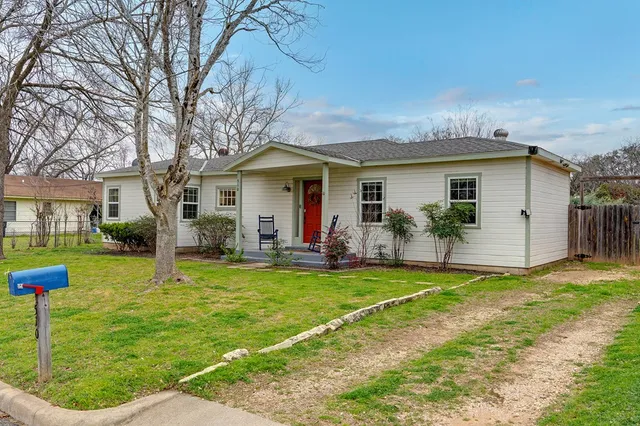 a view of a house with a yard patio and fire pit