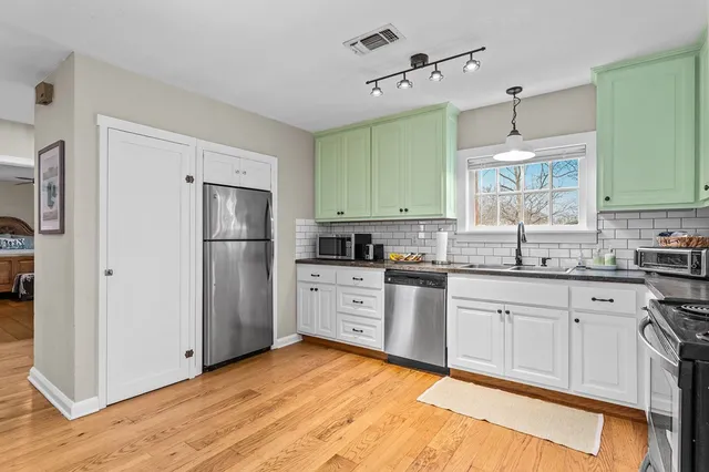 a kitchen with white cabinets and stainless steel appliances