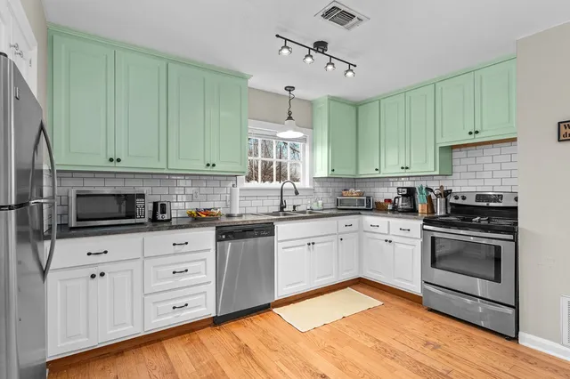 a kitchen with granite countertop a sink a stove and cabinets