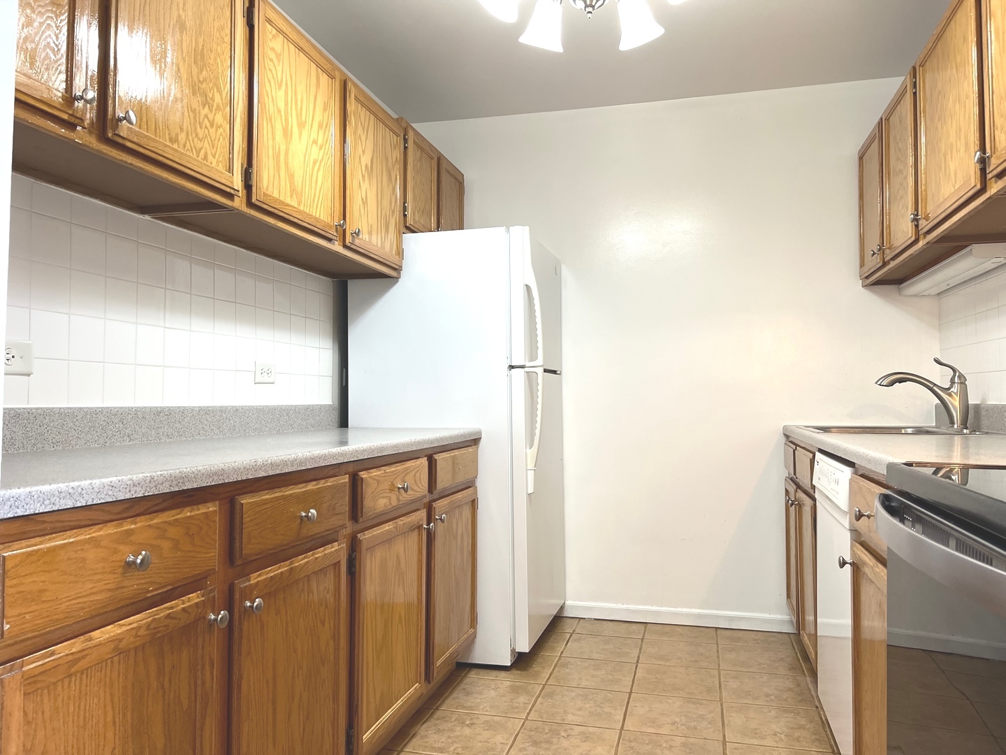 3255 Kirchoff Road, Unit 312 Rolling Meadows, IL 60008 - Photo 6 of 12 a kitchen with stainless steel appliances granite countertop a refrigerator and a sink