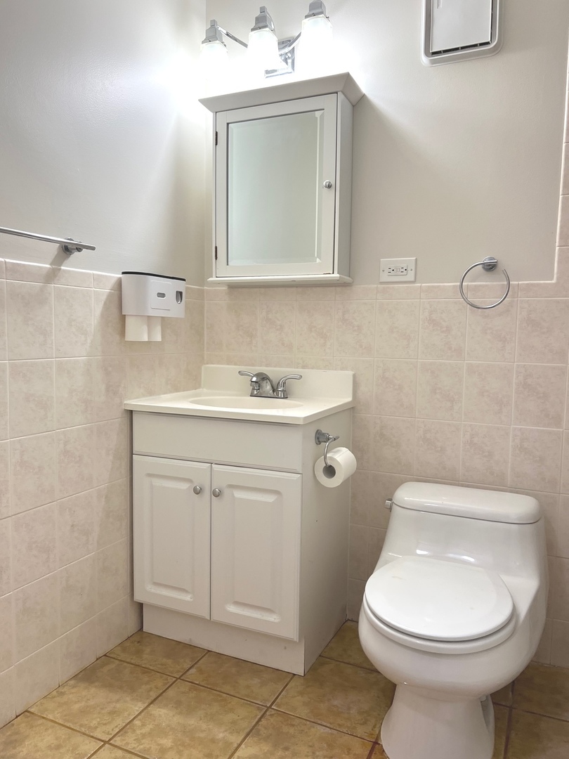 3255 Kirchoff Road, Unit 312 Rolling Meadows, IL 60008 - Photo 7 of 12 a bathroom with a sink toilet and mirror