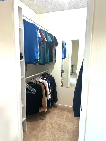 a view of walk in closet with clothes and shoes