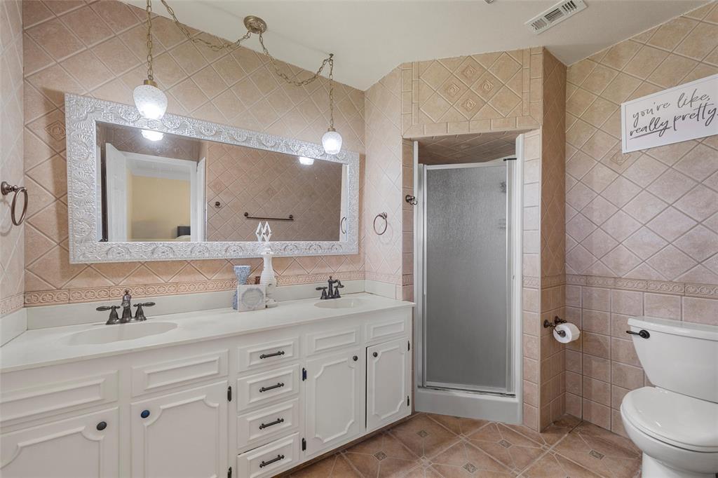 3433 West Tours Road West, TX 76691 - Photo 25 of 40 Full bathroom with tile walls, light tile patterned flooring, a shower stall, double vanity, and backsplash