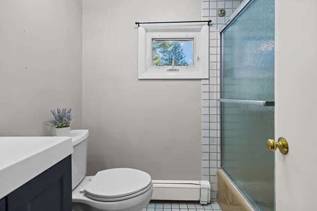 a bathroom with a toilet and a shower