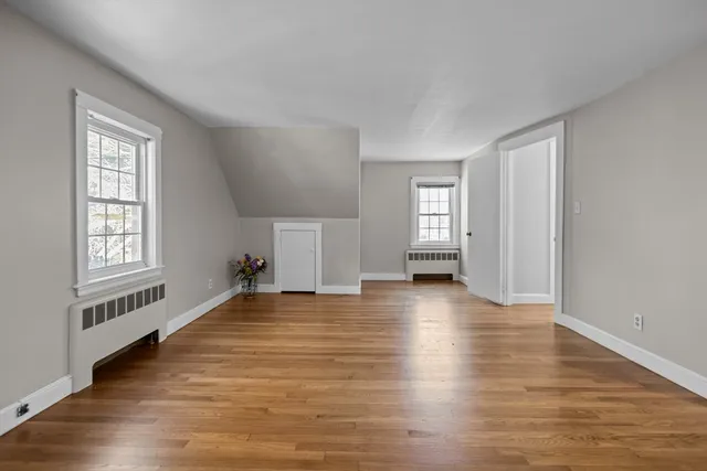 a view of empty room with window and wooden floor