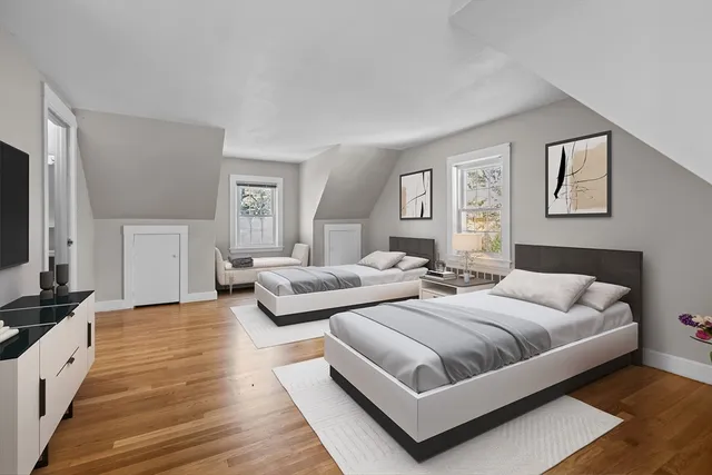 a bedroom with two beds and a flat screen tv