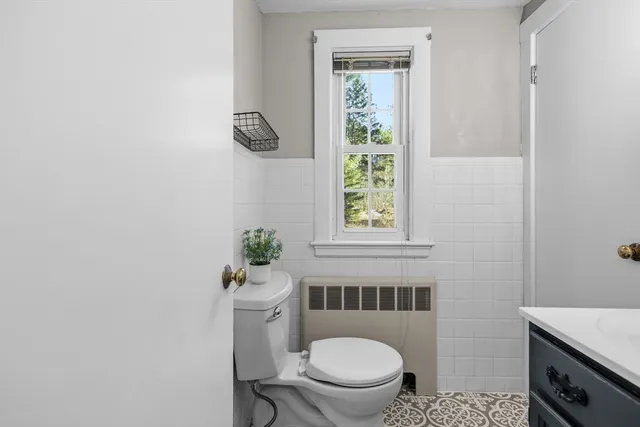 a bathroom with a toilet a window and shower