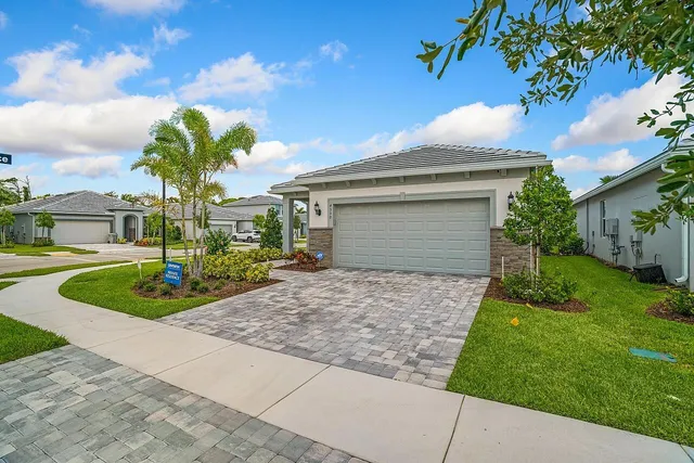 a front view of a house with a garden and trees