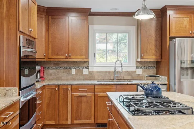 a kitchen with granite countertop a stove a sink dishwasher and cabinets with wooden floor