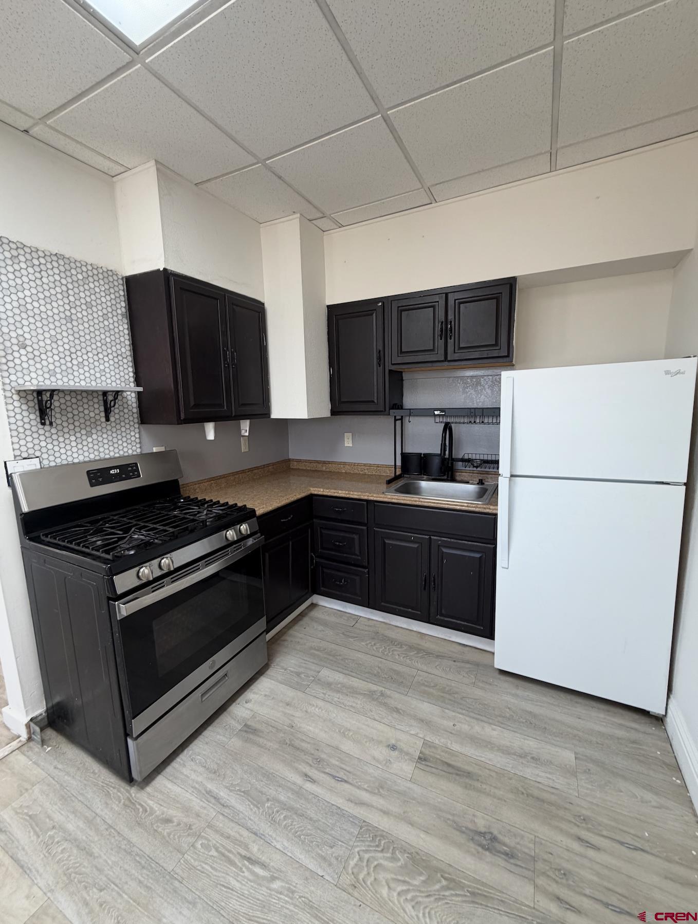 1001 Main Street Delta, CO 81416 - Photo 16 of 29 a kitchen with granite countertop a refrigerator and a stove top oven