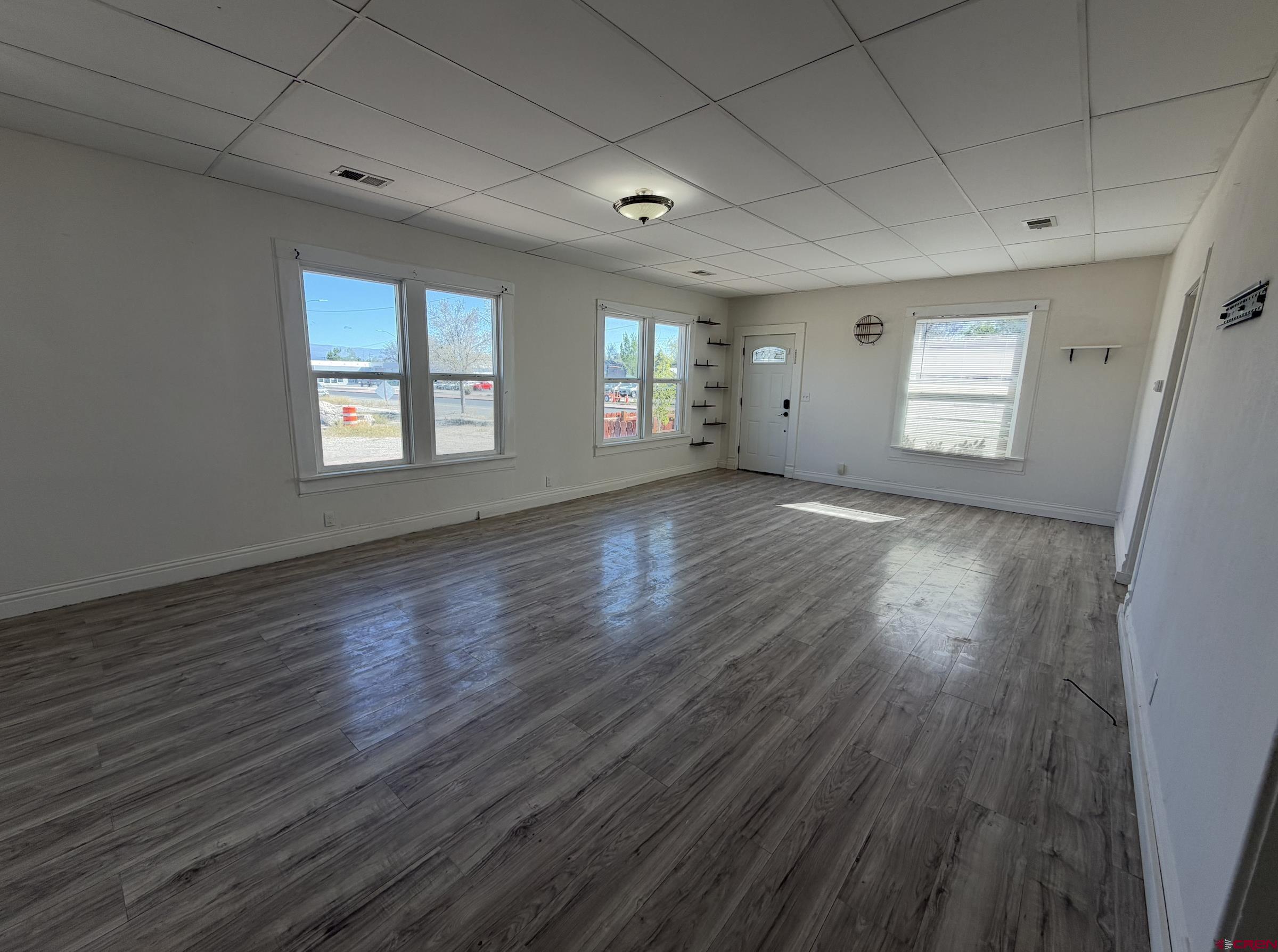 1001 Main Street Delta, CO 81416 - Photo 4 of 29 an empty room with wooden floor and windows