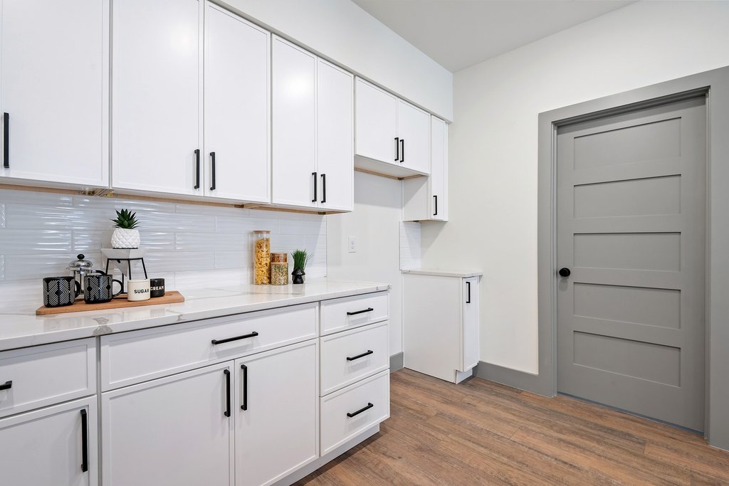 2450 Wickersham Lane, Unit 1927 Austin, TX 78741 - Photo 11 of 40 a kitchen with stainless steel appliances white cabinets and a wooden floor