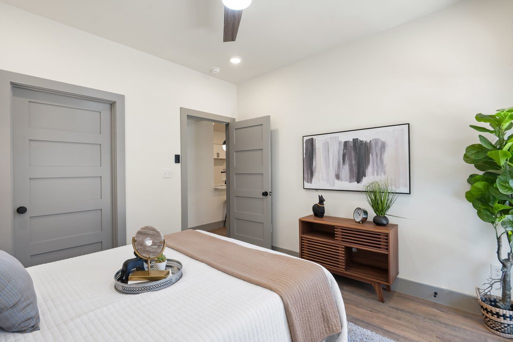 2450 Wickersham Lane, Unit 1927 Austin, TX 78741 - Photo 15 of 40 a bedroom with a bed and a potted plant