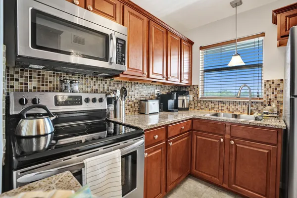 a kitchen with stainless steel appliances granite countertop a stove microwave and sink