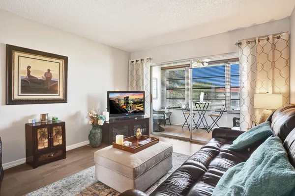 a living room with furniture a flat screen tv and a large window