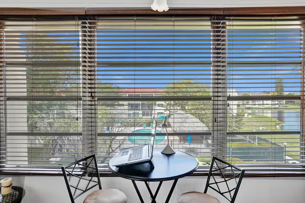a view of a balcony with table and chairs and potted plants