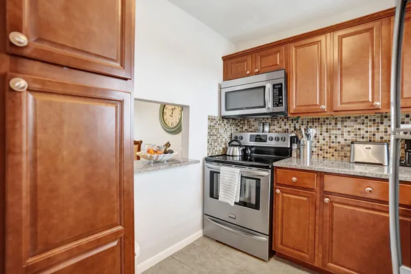 a kitchen with stainless steel appliances granite countertop a stove a sink and a microwave