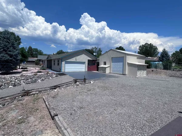 a view of a house with backyard and trees