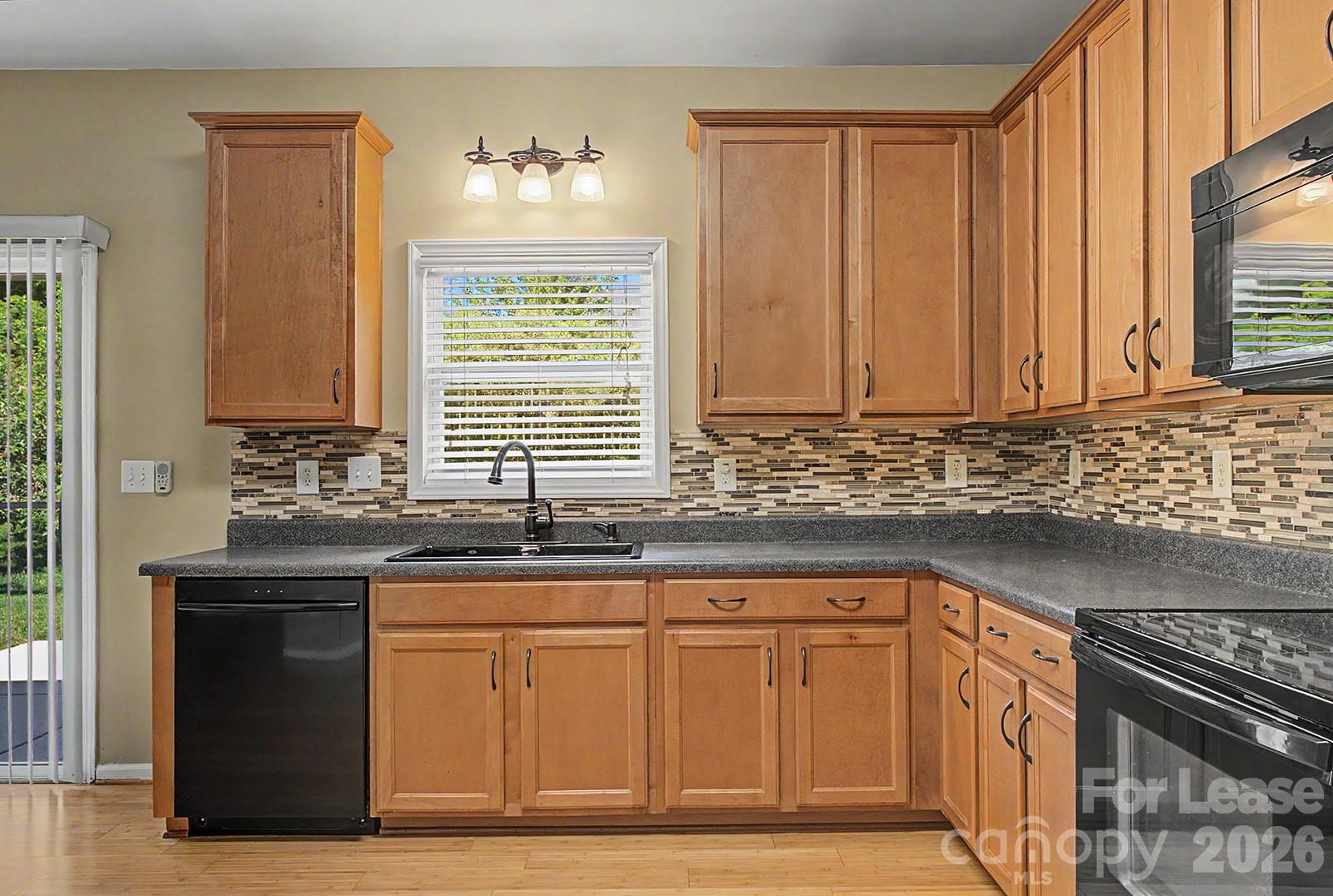 2917 Liddington Road Matthews, NC 28105 - Photo 11 of 44 a kitchen with granite countertop a sink stove and cabinets