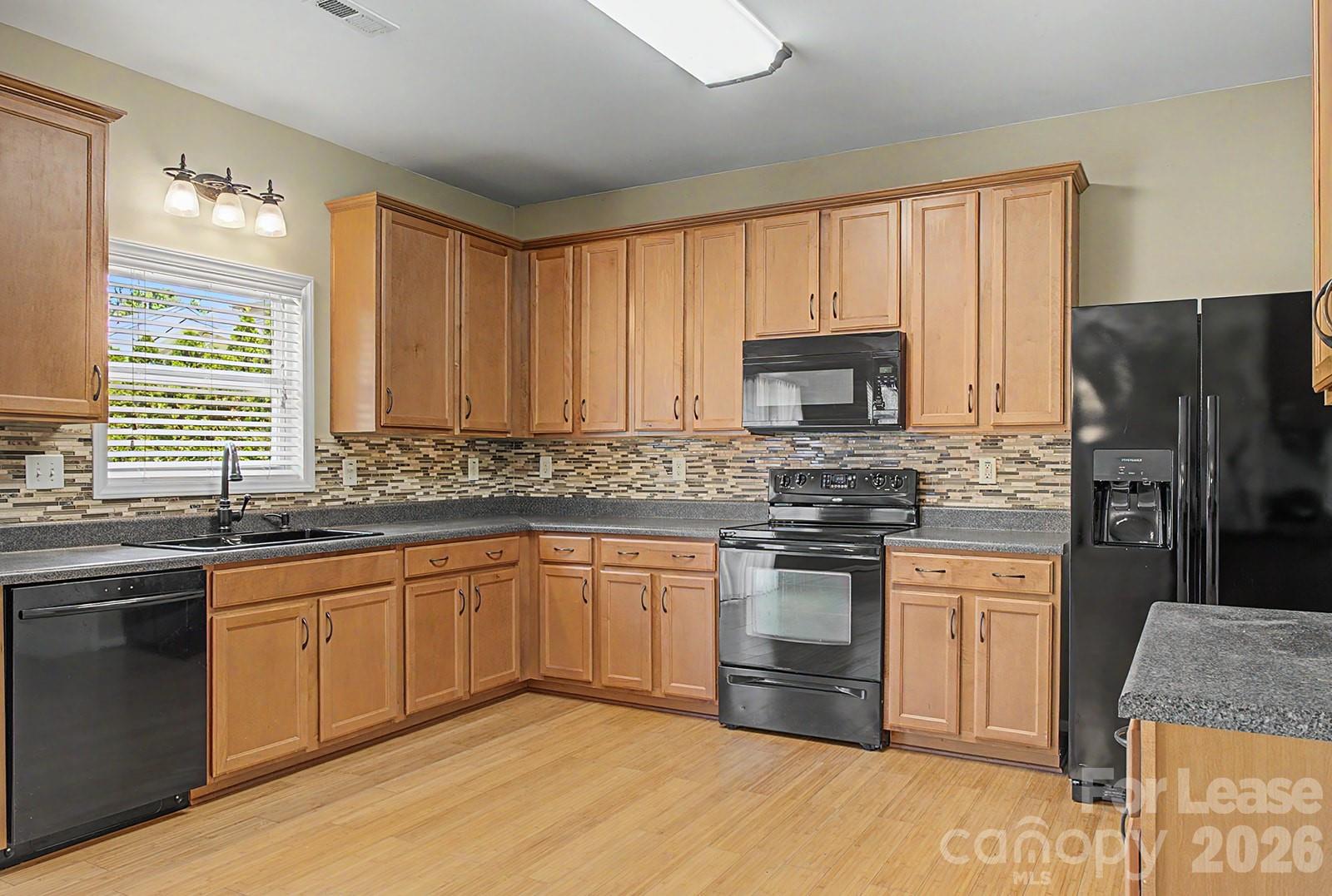 2917 Liddington Road Matthews, NC 28105 - Photo 12 of 44 a kitchen with stainless steel appliances granite countertop a stove a sink dishwasher a refrigerator and a microwave oven