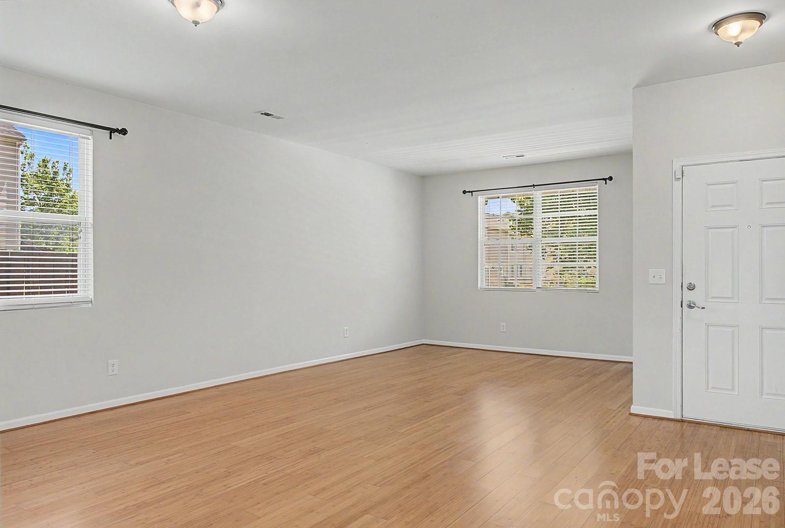 2917 Liddington Road Matthews, NC 28105 - Photo 5 of 44 an empty room with wooden floor and windows