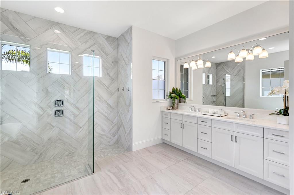8912 Nevis Way Naples, FL 34112 - Photo 16 of 45 Bathroom featuring double vanity, walk in shower, and recessed lighting