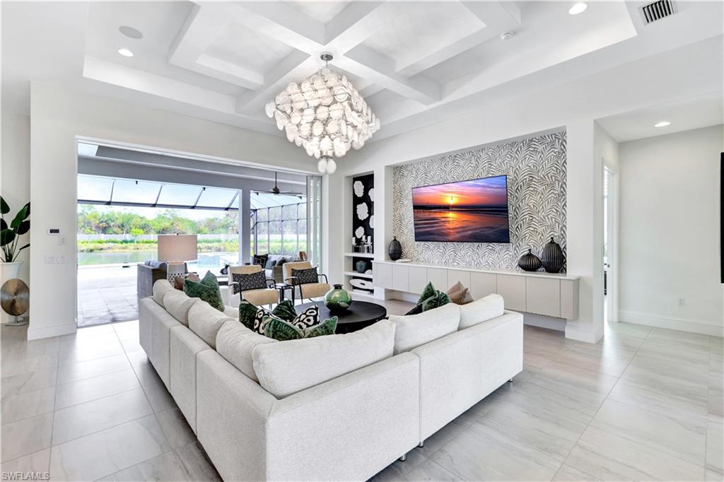 8912 Nevis Way Naples, FL 34112 - Photo 2 of 45 Living area with a sunroom, a chandelier, recessed lighting, coffered ceiling, and beam ceiling