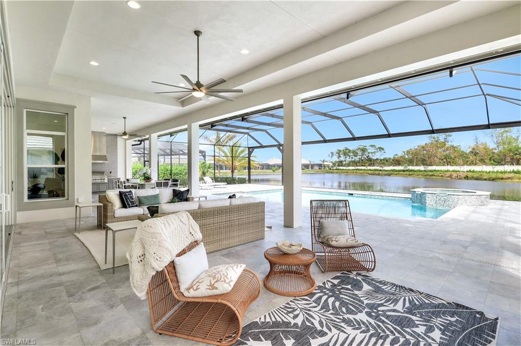 8912 Nevis Way Naples, FL 34112 - Photo 25 of 45 View of patio / terrace with a sunroom, a ceiling fan, a water view, glass enclosure, and a pool with connected hot tub