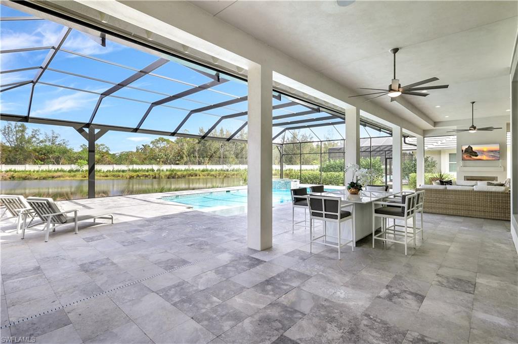 8912 Nevis Way Naples, FL 34112 - Photo 29 of 45 Swimming pool featuring a patio area, a sunroom, a lanai, a water view, and an outdoor living space