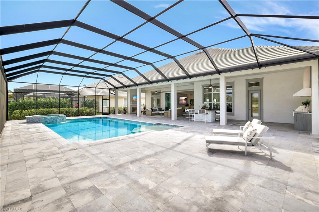 8912 Nevis Way Naples, FL 34112 - Photo 33 of 45 View of pool featuring a sunroom, glass enclosure, and a patio area