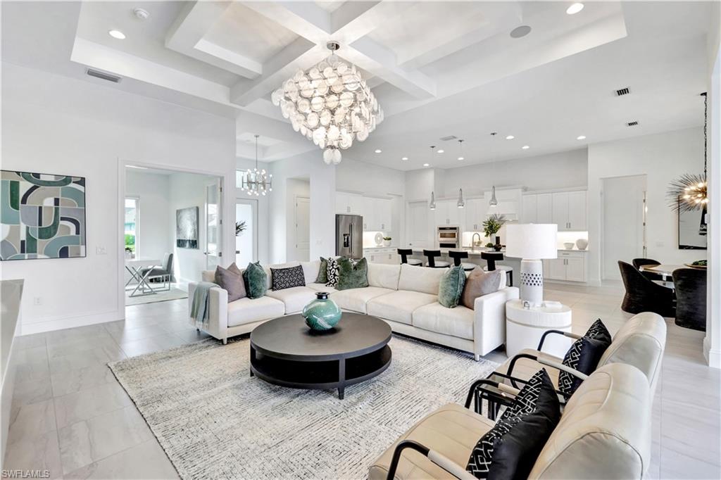 8912 Nevis Way Naples, FL 34112 - Photo 5 of 45 Living area with a chandelier, coffered ceiling, beam ceiling, recessed lighting, and light tile patterned floors