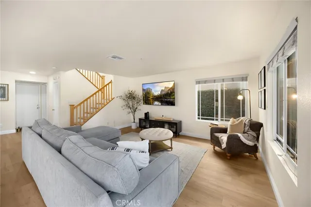 a living room with furniture flat screen tv and a large window