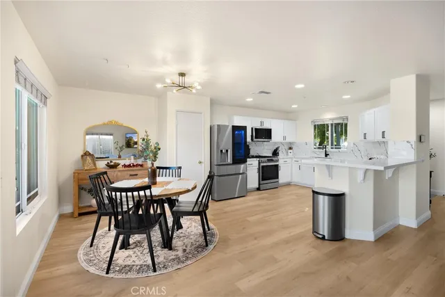 a view of kitchen with stainless steel appliances kitchen island dining table and chairs