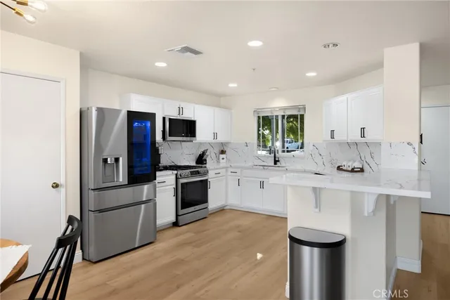 a kitchen with white cabinets and stainless steel appliances