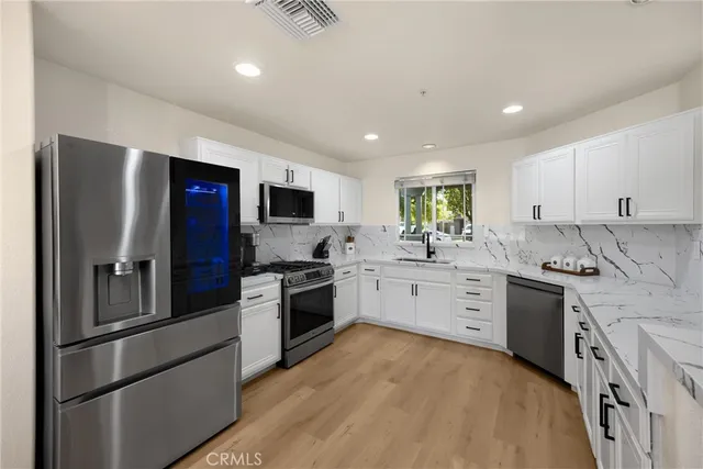 a kitchen with granite countertop appliances cabinets and a sink