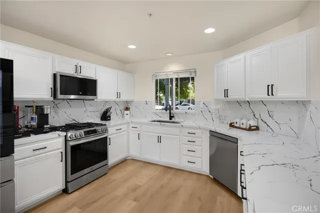 a kitchen with stainless steel appliances granite countertop a stove sink and cabinets