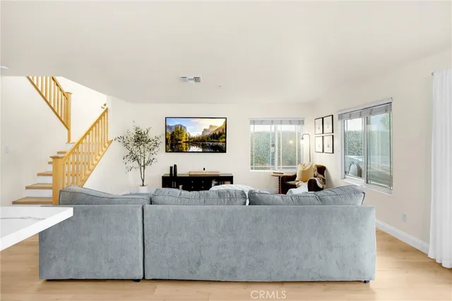 a living room with furniture a flat screen tv and a large window