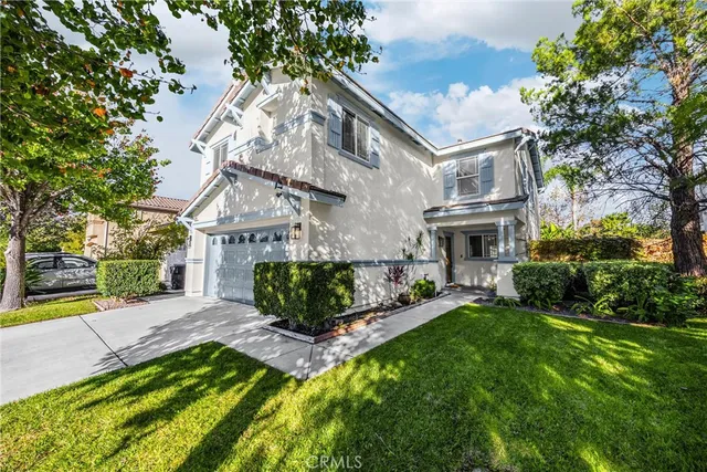 a front view of a house with a garden and plants