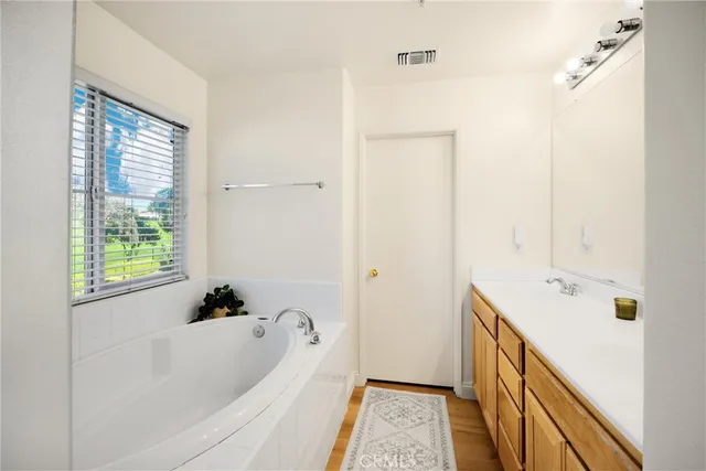 a bathroom with a tub sink and mirror