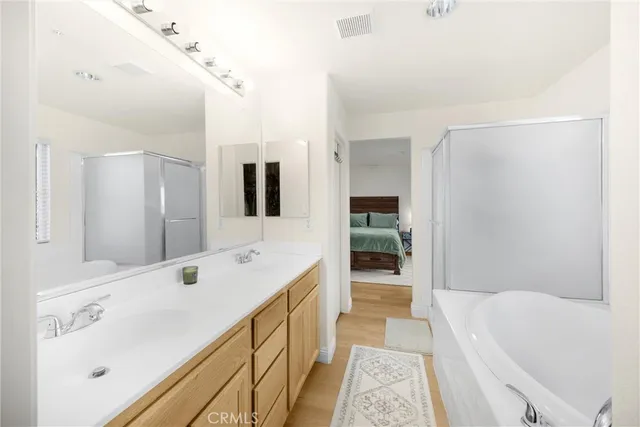 a spacious bathroom with a tub sink and mirror