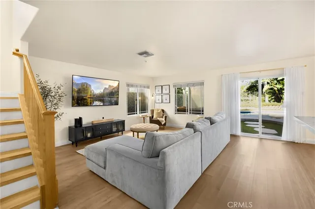 a living room with furniture wooden floor and a flat screen tv