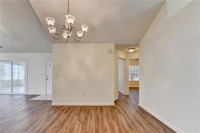 a kitchen with stainless steel appliances granite countertop a refrigerator a sink and white cabinets